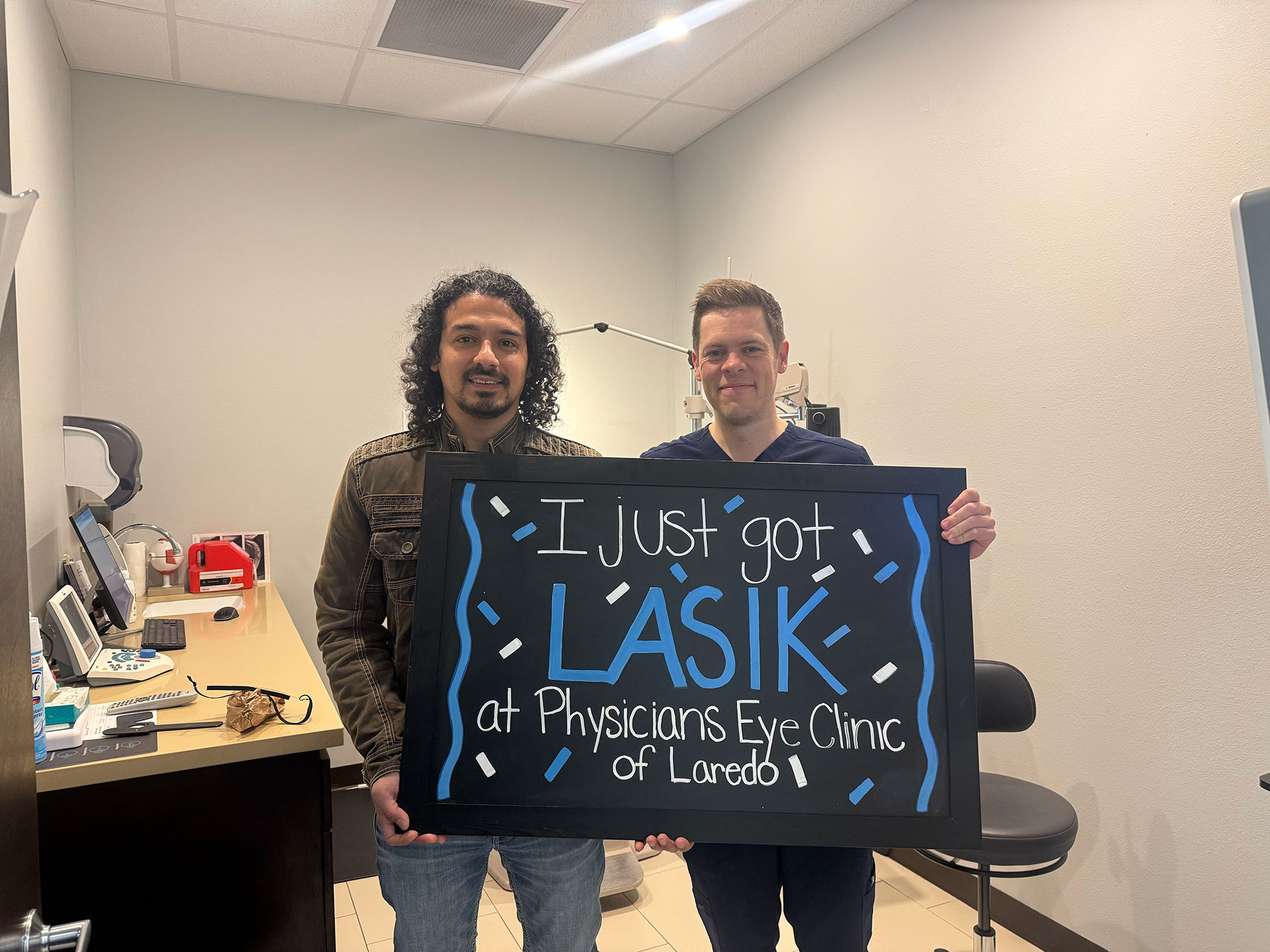 Dr. McNutt with a Physicians Eye Clinic of Laredo LASIK patient holding an 'I just got LASIK' chalkboard