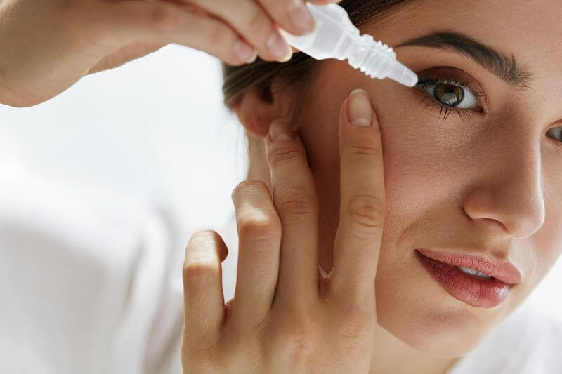 Woman using eye drops for dry eye relief